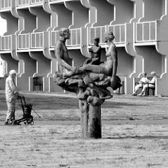 Kunst im öffentlichen Raum - Skulptur Familie mit Kind auf der Freizeitwiese einer Hotelanlage an der Strandpromenade von Kühlungsborn.