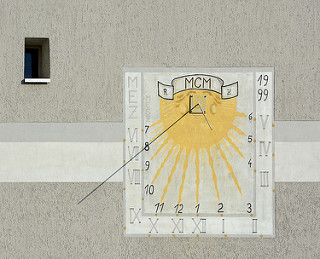 Sonnenuhr mit arabischen und römischen Ziffern an einem Gebäude mit Rauputz in der Stadt Oderberg.