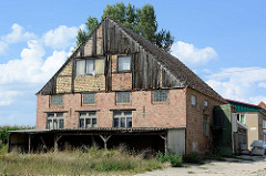 Altes Speichergebäude, Backsteinmauern mit teilweiser Fassadenverkleidung aus Holz; Architektur in Gartz/Oder.
