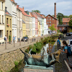 Blick von der Schweinsbrücke in der Hansestadt Wismar auf die Mühlengrube / Mühlenbach und die historischen Wohnhäuser mit unterschiedlich farbige Fassade. Im Hintergrund das historische Gebäude der Stadtmühle, die 1856 errichtet wurde und als Indus