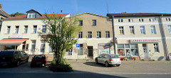 Geschäftszeile in der Berliner Straße von Oderberg, rechts die Landesapotheke, links die Landfleischerei - das Gebäude in der Mitte war ein ehemaliges Fahrradgeschäft, das jetzt leer steht und mit einem Bauzaun abgesperrt ist.