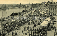 Historische Ansicht vom Maasufer in Lüttich / Liège; Binnenschiffe liegen am Kai - am Ufer findet ein Markt statt.