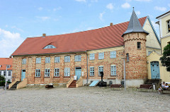 Schlossplatz von Bützow, Krummes Haus; ursprünglich Wirtschaftsgebäude und Pferdestall der bischöflichen Burg. 1769 als Bibliothek umgebaut, dann Nutzung durch sogenannte Gnadenwohnungen. Ab 2000 wird das historische Gebäude als Bibliothek und Heima