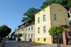 Neubau eines Wohnhauses mit TonnenDach, daneben ein denkmalgeschütztes Gebäude in der Angermünder Straße von Oderberg.