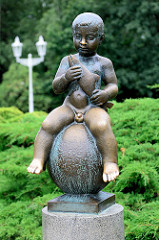 Statue des Franzel oder Franzl (František) in den Kuranlagen von Franzensbad / Františkovy Lázně; ein nackter Junge mit Fisch sitzt auf einer Kugel,  die Statuette gilt als Fruchtbarkeitssymbol - Bildhauer  Karl Mayerl, 1912.