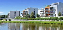 Moderne Wohnhäuser am Ufer der Moldau / Vitave in der tschechischen Stadt Budweis /  České Budějovice.