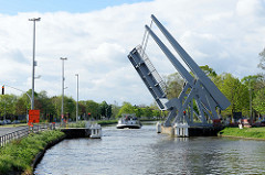 Das Binnenschiff INEMAR fährt durch eine geöffnete Klappbrücke auf dem Gent- Oostende Kanal durch die belgische Stadt Brügge.