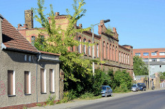 Leerstehende Backsteinarchitektur / Fabrikgebäude mit Gebüsch bewachsen in der Bergerstraße von Eberswalde.