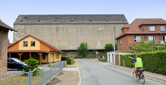 Einzelhäuser /Wohnhäuser im Werkweg von Güstrow, Blick auf die graue fensterlose massive Fassade eines Lagergebäudes Sankt Jürgens Weg.