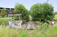 Stillgelegter, verwahrloster alter Lokschuppen an der Bahnstrecke in Güstrow - im Vordergrund die Auffahrt / Schienen zur Drehscheibe.