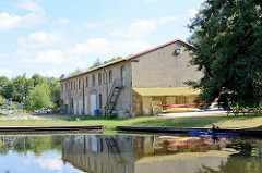 Messinghafen von Finow am Finowkanal, am Ufer ein Lagergebäude.