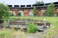 Stillgelegter, verwahrloster alter Lokschuppen an der Bahnstrecke in Güstrow - im die Vordergrund die Drehscheibe