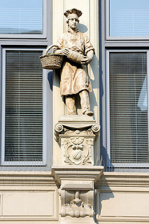 Bäckerjunge mit Brotkorb und Brotlaib - Skulptur an der Hausfassade einer ehem. Bäckerei beim Nordermarkt in Flensburg.