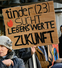 Handgeschriebenes Pappschild mit der Aufschrift:   tinder (23) sucht liebenswerte Zukunft. Fast 10 000 SchülerInnen protestieren am 15.03.2019 bei der Fridays for Future-Demonstration in Hamburg für mehr Klimaschutz