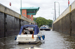 Sportboote und ein beladenes Binnenschiff verlassen die Schleusenkammer des Elbe-Lübeck-Kanals bei Lauenburg.