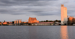 Abendstimmung am Hafen / Ziegelsee von Mölln - die untergehende Sonne scheint rötlich auf die Silos und Speichergebäude am Hafenrand.
