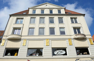 Hausfassade mit goldenen Reliefdarstellungen in der Großen Straße von Flensburg.