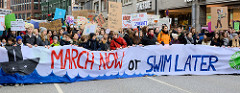 Fridays for Future - Demo in Hamburg - 01.03.2019. Spitze des Demonstrationszuges am Gänsemarkt - Transparent March now or swim later.