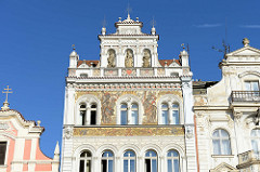 Giebel eines Wohn- und Geschäftshauses am Platz der Republik / náměstí Republiky in der denkmalgeschützten Altstadt von Pilsen / Plzeň.  Aufwändige Fassadenmalerei mit Jahreszahl 1894 - Skulpturen in Muschelnischen.
