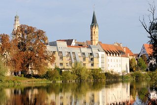 Die Stadt Lauingen , Donau liegt im Landkreis Dillingen im Donautal in Bayern. Blick über die Donau,herbstlich gefärbte Bäume stehen am Donauufer, moderne Wohnhäuser, dahinter der Schimmelturm und der Kirchturm der Spitalkirche St. Alban.