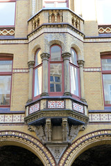 Bilder aus der Hamburger Innenstadt - Stadtteil Neustadt. Hausfassade mit gelben Backstein - Erker mit Säulen und farbigem Blattwerk in den Colonnaden.