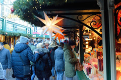 Weihnachtsmärkte in der Innenstadt - Altstadt von Hamburg. Verkaufsstand mit beleuchteten Weihnachtssternen auf dem Hamburger Rathausmarkt.