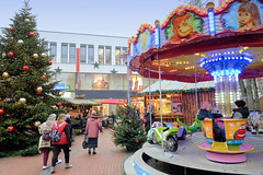 Bilder aus der Stadt Elmshorn, Metropolregion Hamburg. Weihnachtsmarkt am Alten Markt an der Nikolaikirche - mit bunten Kugeln geschmückter Tannenbaum, Kinderkarussell.