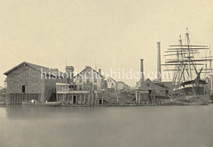 Historische Fotografie vom Reiherstieg in Hamburg Steinwerder - Werft mit Segelschiff, Schornsteine und Lagerhäuser.