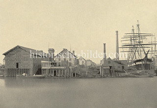 Historische Fotografie vom Reiherstieg in Hamburg Steinwerder - Werft mit Segelschiff, Schornsteine und Lagerhäuser.