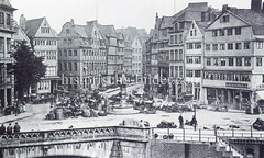Historische Bilder vom Messberg in der Hamburger Altstadt, Innenstadt. Der Marktplatz am Messberg ca. 1880; in der Bildmitte der Vierländer Brunnen und einige Marktstände. Im Vordergrund lks. das steinerne Geländer der Wandrahmsbrücke.