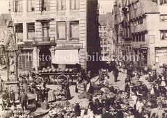 Historische Bilder vom Messberg in der Hamburger Altstadt, Innenstadt. Bauernmarkt auf dem Messberg; am Brunnenrand des Vierländer Brunnens sitzen zwei Jungen. Der Brunnen wurde 1878 errichtet; unter einem schmiedeeisernen Baldachin