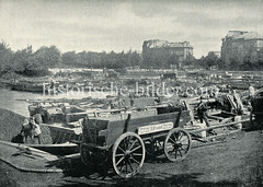 Historische Fotografie von der Hohenfelder Bucht im Stadtteil Hamburg Hohenfelde. Pferdefuhrwerke stehen am Ufer der Bucht - auf dem Wasser div. Lastkähne und Schuten.