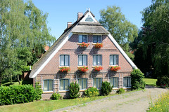 Fotos aus dem Hamburger Stadtteil Altengamme, Vierlande - Bezirk Hamburg Bergedorf. Reetgedecktes Wohnhaus mit Geranienkästen vor den Fenstern am Altengammer Elbdeich.