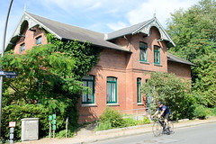 Neuengamme  ist ein Hamburger Stadtteil im Elbmarsch-Gebiet der Vierlande im Bezirk Bergedorf. Wohnhaus mit Ziergiebel, Schnitzwerk am Neuengammer Hausdeich, Rennradfahrer.