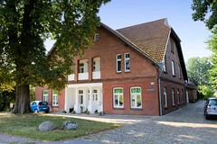 Fotos aus dem Hamburger Stadtteil Reitbrook, Bezirk Bergedorf. Historisches Wohnwirtschaftsgebäude am Vorderdeich; das Bauernhaus mit Bäumen und Pflasterung wurde um 1911 errichtet und steht unter Denkmalschutz - Architekt C. Kahlbrandt.