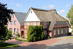 Fotos aus dem Hamburger Stadtteil Reitbrook, Bezirk Bergedorf. Wohnhaus mit Reetdach und Fachwerk, daneben Neubau am Vorderdeich.