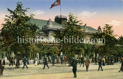 Blick über den Jungfernstieg zum Alsterpavillion - die Hamburg Fahne weht auf dem Dach, auf der Terrasse stehen hohe Palmen.