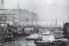Alte Aufnahme vom Altonaer Holzhafen (ca. 1885). Beladene Schuten und ein Hausboot liegen geschütze zwischen Ponton und Kaimauer - Industriearchitektur direkt am Wasser.