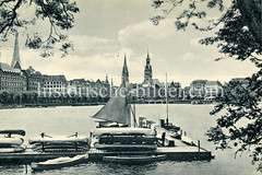 Historische Ansicht von der Binnenalster, Blick auf die Hamburger Altstadt; im Vordergrund Bootsverleih mit Kanus und Segelbooten.