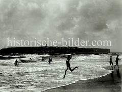 Baden am Strand - hohe Wellen, im Hintergrund die Hauptinsel Helgoland.