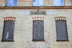 Die Kleinstadt Warin liegt im Landkreis Nordwestmecklenburg in Mecklenburg-Vorpommern. Mit Spanplatten vernagelte Fenster Relief Amtsgericht.
