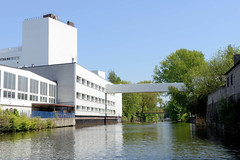 Weisse Industriearchitektur mit Fussgängerbrücke über den Südkanal in Hamburg Hamm.