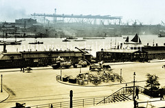Blick auf die St. Pauli Landungsbrücken - Handkarren, Pferdefuhrwerk und Lastwagen  stehen bereit;  am anderen Elbufer Werftanlagen   (ca. 1923)..