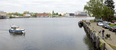 Fotos aus dem Hamburger Stadtteil Rothenburgsort, Bezirk Hamburg Mitte; Blick von der grünen Brücke - Angler sitzen am Kai der Hafenanlage an der Bille, ein Sportboot legt an.