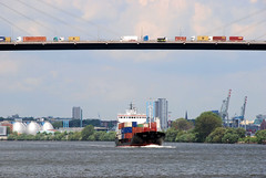 Fotos der Köhlbrandbrücke im Hamburger Hafen - Verbindung zwischen den Stadtteilen Steinwerder und Wilhelmsburg; Autoverkehr auf der Brücke - ein Feederschiff fährt auf dem Köhlbrand - im Hintergrund das Klärwerk Köhlbrandhöft.