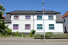 Teterow  ist eine Stadt im Landkreis Rostock in Mecklenburg-Vorpommern; Doppelhaus mit unterschiedlicher Fassadengestaltung / Vorgarten in der Otimarstraße.