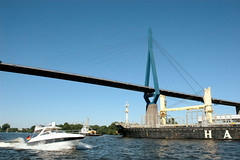 Fotos der Köhlbrandbrücke im Hamburger Hafen - Verbindung zwischen den Stadtteilen Steinwerder und Wilhelmsburg; ein Sportboot + Frachter fahren unter der Brücke.