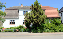 Teterow  ist eine Stadt im Landkreis Rostock in Mecklenburg-Vorpommern; Doppelhaus mit unterschiedlicher Fassadengestaltung / Vorgarten in der Otimarstraße.