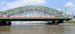 Blick auf die Freihafenelbbrücke über die Norderelbe in Hamburg Rothenburgsort / Hafencity - ein Zug der S-Bahn fährt auf der Brücke, re. Baukräne der Hafencity und die Haltestelle Elbbrücken.
