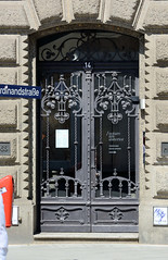 Fotos aus dem Hamburger Stadtteil Altstadt, Bezirk Hamburg Mitte; Eingangstür mit schmiedeeiserner Verzierung vom  Heintzehof am Alstertor - das Kontorhaus wurde 1900 errichtet - Architekten Krumbhaar & Heubel.